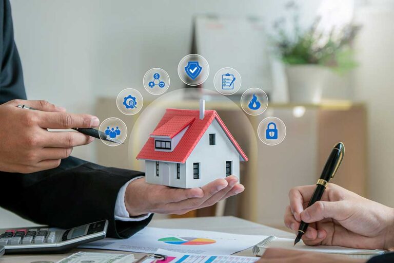 A person reviews insurance documents and a payment notice on a kitchen table with a cup of coffee nearby.